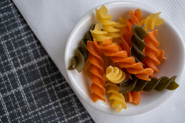 plato redondo pequeño con pasta fusilli con vegetales en su composición con espacio para texto
