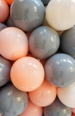 Colorful balloons in various shades of orange, gray create vibrant arrangement. Balloons neatly grouped together, appear to part of larger display. Image evokes cheerful, celebratory atmosphere
