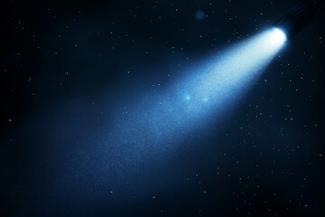 A bright blue spotlight illuminates a dark, starry night sky. Cosmic dust particles are visible in the beams path. The scene evokes a sense of mystery and wonder.