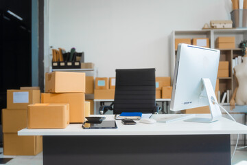 A workspace with a desk, tablet, and computer PC, used by an SME business owner managing an online...