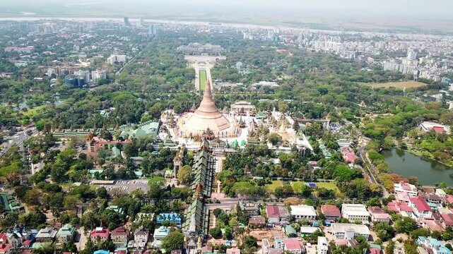 Impressive aerial view capturing the Shwedagon Pagoda, a magnificent golden stupa and landmark in Rangun, Myanmar, surrounded by a bustling cityscape