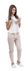 Woman dressed in cozy homewear holding a smartphone and a coffee cup, standing casually on white background. Concept of relaxation and lifestyle