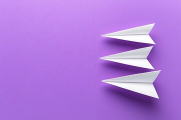 Three White Paper Airplanes on Purple Background