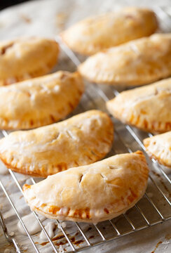 Rows of Sweet Iced Handpies Filled Pastries on a metal cooling rack