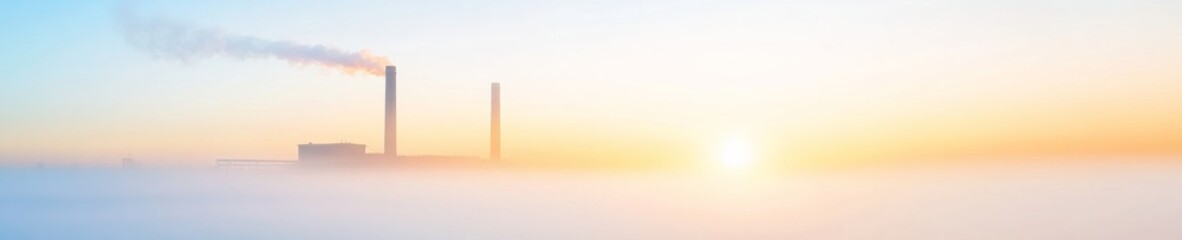 Fototapeta premium Ethereal Sunrise Over Abandoned Power Plant in Foggy Landscape