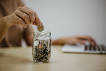 A person holds a stack of coins, which symbolizes financial success, economic planning, and future security, emphasizing the importance of building financial wealth.
