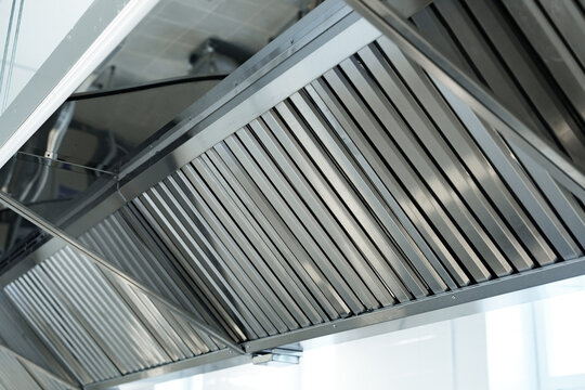 Stainless steel kitchen exhaust hood installed in modern commercial kitchen for improved ventilation and safety