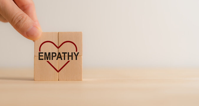 Empathy concept. Wooden blocks with empathy icons on minimal background and copy space. The power of emotional intelligent, soft skill development. Empathy in the workplace, good leaders, good teams. 