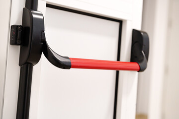 Red resistance band attached to a door for strength training exercises in a home gym setting