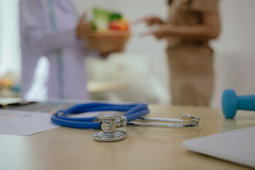 Female doctor or nutritionist sitting at table with fresh fruits and vegetables to promote healthy eating and living, nutrition and weight control.