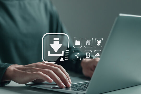 Person using laptop with download icons on virtual screen. Download organizational information or documents. Data Storage, cloud storage technology.