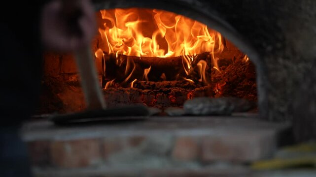 Baker Removes Freshly Baked Simits from Traditional Oven with Shovel, Rustic Flame Fire