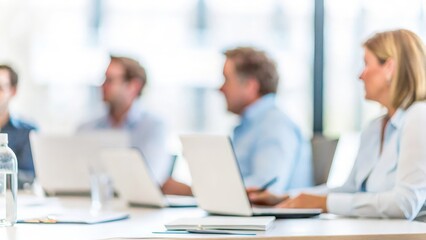 Obraz premium Corporate Meeting Presentation – A business meeting with a blurred background and a team listening attentively. 