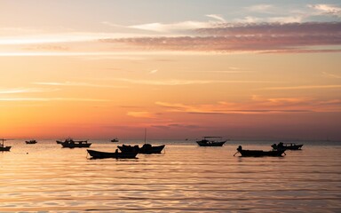 Obraz premium Sunset at Manila Bay Silhouetted fishing boats at sunset on calm sea.