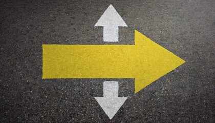 A yellow arrow with two white arrows pointing up and down on a textured surface, indicating directions for traffic or movement.