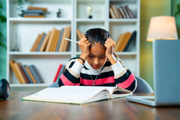 Stressed Indian Girl Writing Notes During Online Class at Home – Homework and Digital Learning