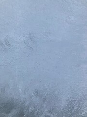 Close-up of an ice wall with tiny air bubbles. Outdoors in winter. Frozen.