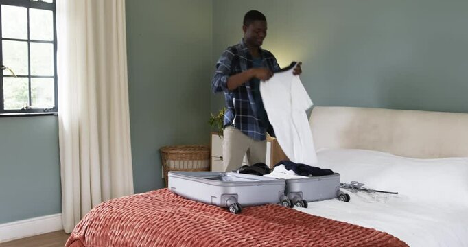 Man packing suitcase in bedroom, preparing for holiday travel with joy