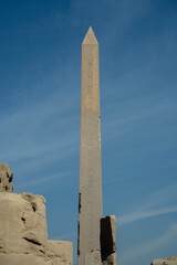 Egyptian Ancient Obelisk Behind Walls of Ruined Wall Against Sky