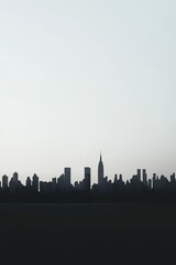 Obraz premium A breathtaking view of a city skyline silhouetted against a clear evening sky, showcasing iconic skyscrapers.