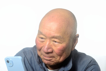 笑顔でスマートフォンを操作する老人