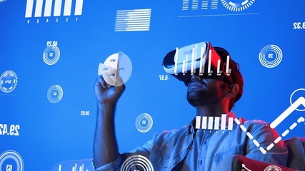 Business man wearing VR headset while looking at financial graph and analyzing statistic chart....
