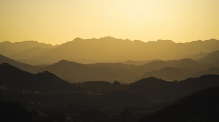 Serene mountain landscape at sunset, showcasing layered hills and a warm color palette.
