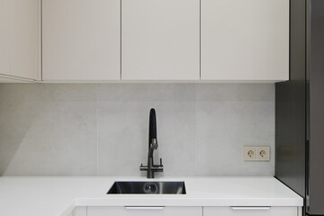 Modern kitchen design featuring sleek cabinetry and black stainless steel sink