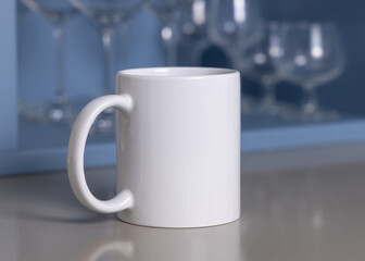 White coffee mug on grey kitchen table against blue wine glasses holder closeup, mockup