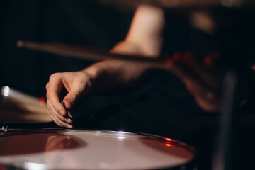 Close up on hands of unknown caucasian woman with drumsticks - unknown female playing drums at night