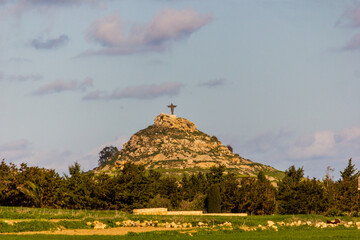 Scenic Hill with Religious Monument Under a Vibrant Sky