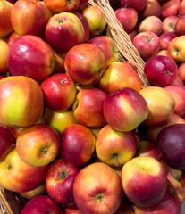 A basket of apples is piled high with red and green apples