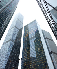 A city skyline with three tall buildings, one of which is a skyscraper