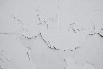 Textured wall with peeling paint revealing layers beneath in urban setting