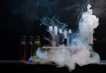 Chemistry glassware test tubes measuring jugs with colourful liquids and swirling smoke