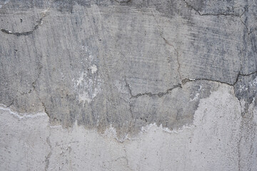 Concrete wall with crack, gray color background, removing plaster from a cement wall, rough surface texture. Renovation of old residential premises and apartments. repair, DIY repairs