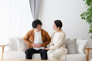 体調不良の男性と気遣う女性