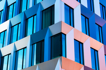 Abstract Modern Facade with Geometric Patterns, Blue and Yellow Panels, and Sunlight Reflections