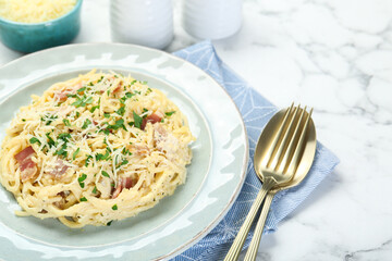 Delicious pasta Carbonara with bacon served on white marble table, closeup