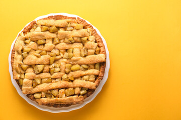 Tasty homemade apple pie on yellow background, top view. Space for text