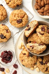Delicious oatmeal cookies with raisins and nuts on white marble table, flat lay