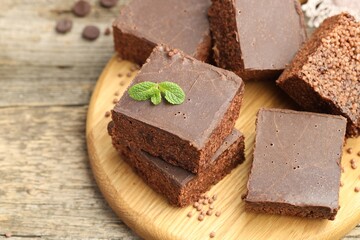 Delicious chocolate puffed rice bars and mint on wooden table, closeup