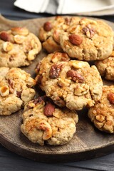 Tasty cookies with nuts on dark wooden table, closeup