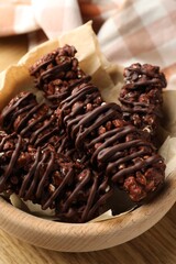 Delicious chocolate puffed rice bars on wooden table, closeup