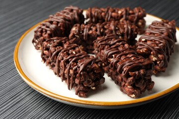 Delicious chocolate puffed rice bars on dark gray wooden table, closeup