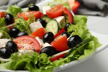 Delicious fresh Greek salad on white table, closeup