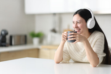 Happy asian woman drinking and listening audio