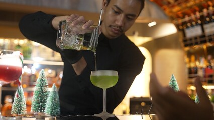 Bartender preparing to serve Midori sour with lime syrup pouring into saucer glass. Focusing special refresh japanese liqueur drink style showcasing nightlife mixology at nightclub luxury. Vinosity.