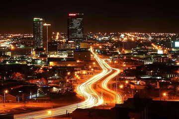 Fototapeta premium Night city skyline with light trails from traffic, urban landscape background.