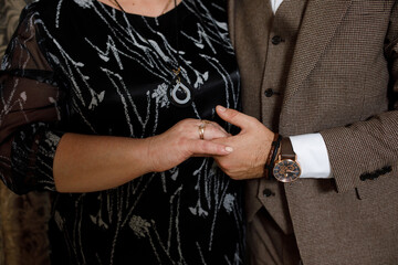 Groom and mother Tney are holding hands, and a gold ring is viscible on the Wotan's finger.